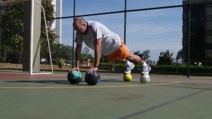 Plank on four medicine balls, balance training