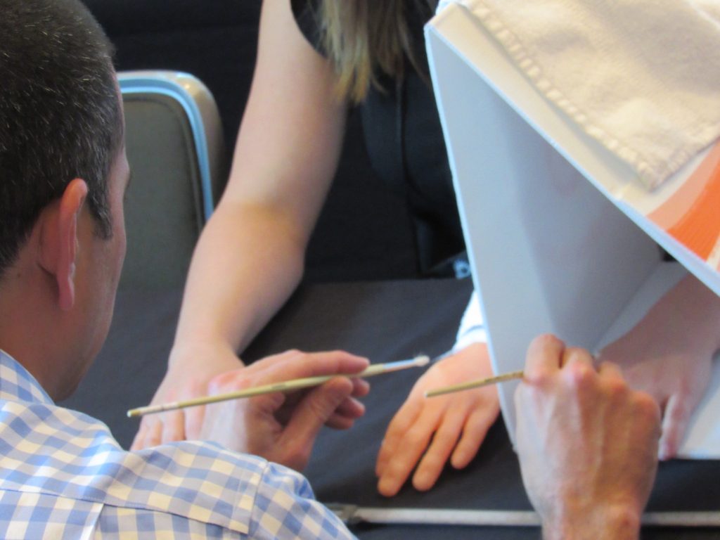 man brushes a woman's real hand and a rubber hand hidden from her view
