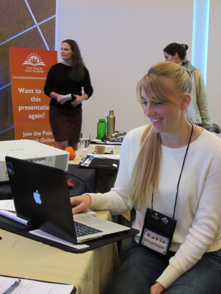 physical thearpist katie schopmeyer checking notes at san diego pain summit