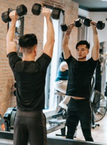 man shoulder press exercise with dumbbells