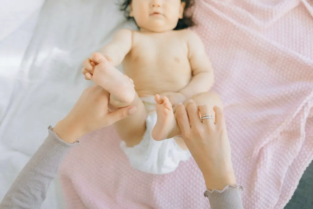 mother giving baby a foot and leg massage