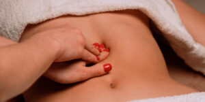 massage therapist giving a woman an abdominal massage for inguinal hernia pain relief